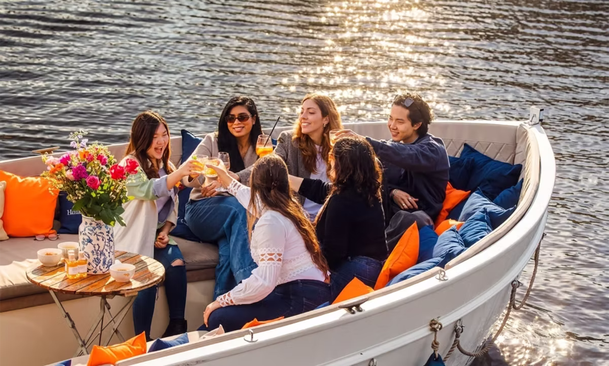 Friends enjoy drinks together on a private Amsterdam canal cruise.